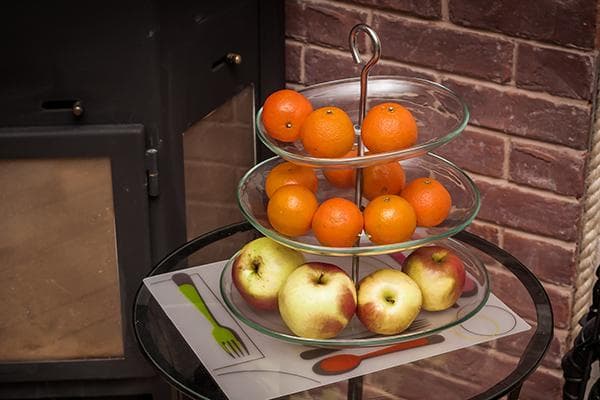 Мандарины и яблоки в этажерке для фруктов